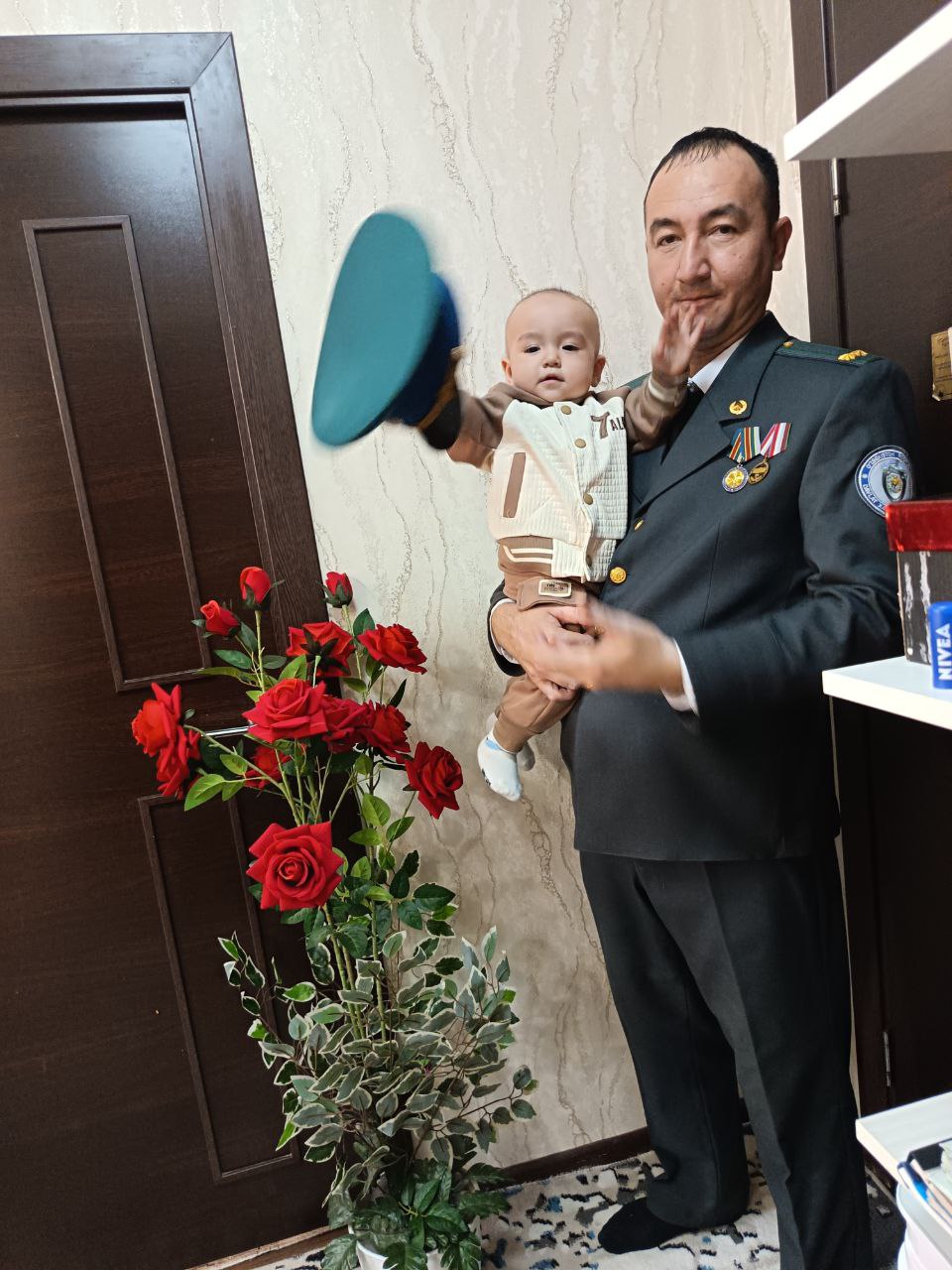 Man in military uniform holding a baby